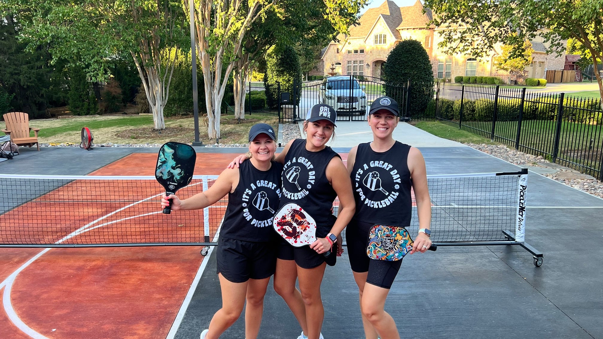 Three girls wearing matching pickleball gear about to play pickleball