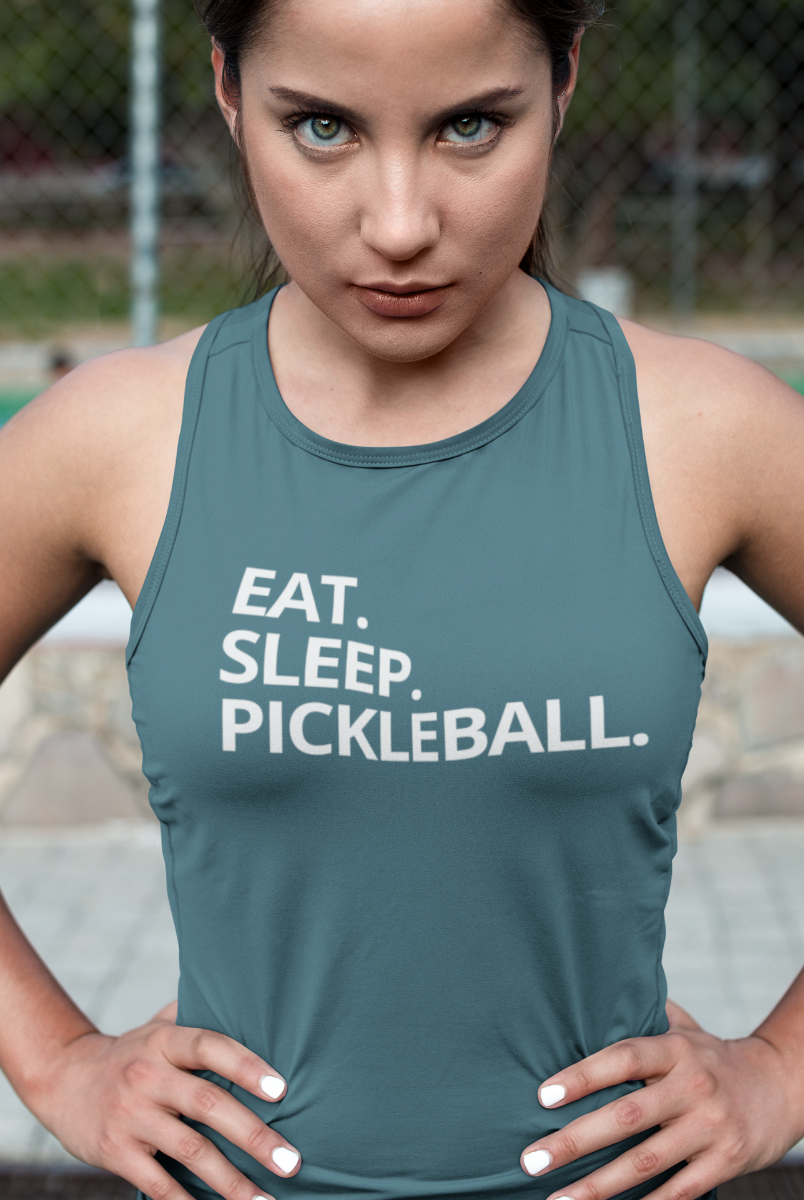 A woman wearing a slate blue-gray athletic tank top with the white text 'EAT. SLEEP. Pickleball.'