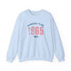 Light Blue pickleball crewneck sweatshirt with a distressed collegiate-style "Bainbridge Island 1965 WA" text stack in navy and coral