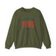 Military Green pickleball crewneck sweatshirt with a distressed collegiate-style "Bainbridge Island 1965 WA" text stack in navy and coral