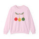 Light pink crewneck sweatshirt with pickleballs styled as Christmas ornaments hanging from a holly branch