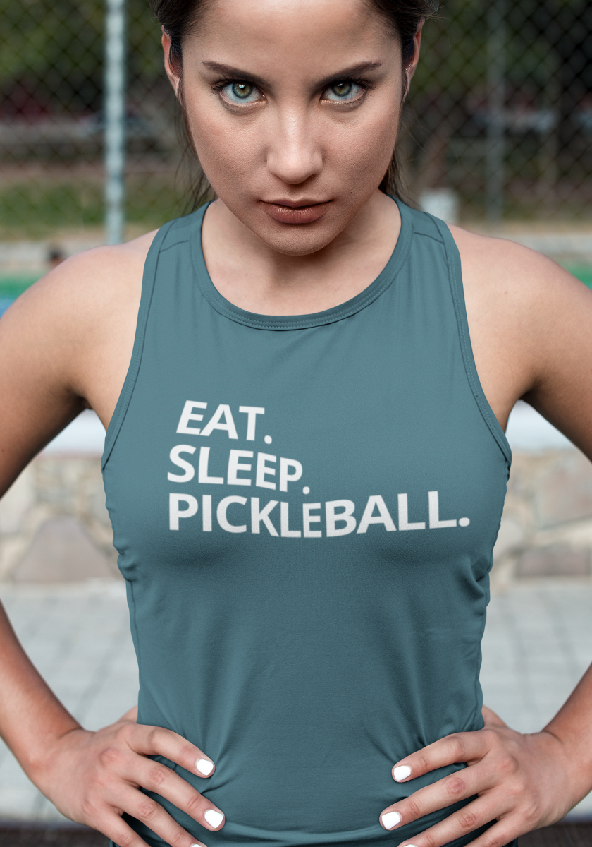 A woman wearing a slate blue-gray athletic tank top with the white text 'EAT. SLEEP. Pickleball.'